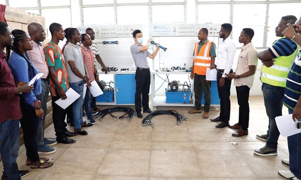 Prof. Zhao Kunming (middle), a Resource Person in Mechanical Engineering, China Education Association for International Exchange, showing the lecturers of the KsTU how the Comprehensive Hydraulic Experiment Device works.